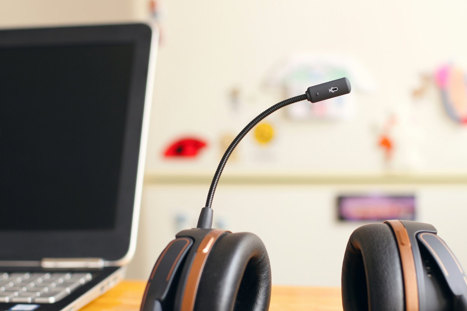 A headset with a boom microphone on a desk next to a laptop, symbolizing customer support or call center service